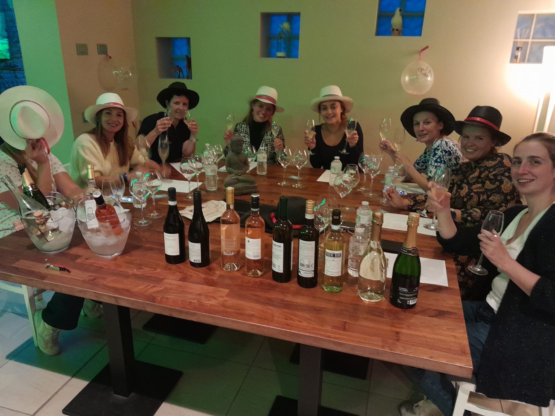 Vriendinnengroep proost met bubbels tijdens een wijnproeverij aan huis